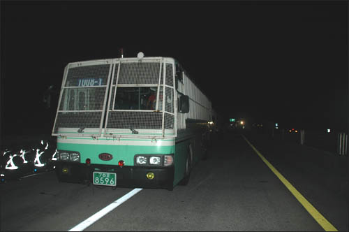  남해고속도로 부산방면 산인톨게이트 부근에 경찰버스가 도로 한 가운데 세워져 있다.